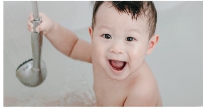 샤워기 아래에서 웃는 아이